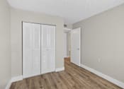 Thumbnail 14 of 31 - Closet with white doors in a room with wood floors.
