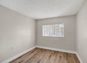 Thumbnail 16 of 31 - A room with a window and wooden flooring.