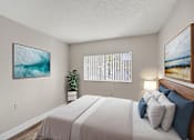 Thumbnail 15 of 31 - A bedroom with a large bed and two framed pictures on the wall.