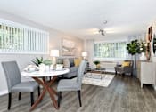 Thumbnail 3 of 21 - A dining room with a round table and grey chairs.