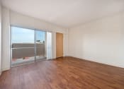 Thumbnail 2 of 27 - an empty living room with wood flooring and sliding glass doors