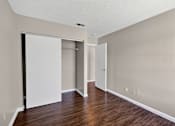 Thumbnail 34 of 41 - A room with a white door and a brown floor.