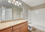 Thumbnail 18 of 22 - Bathroom with granite countertop and tub shower combo at Borgata Condominiums Apartments, Las Vegas, Nevada