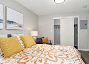 Thumbnail 9 of 21 - A bedroom with a bed, two lamps, and a painting on the wall.
