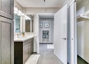 Thumbnail 8 of 14 - A bathroom with a sink, mirror, and a white door.