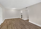 Thumbnail 10 of 31 - A room with wooden flooring and white walls.