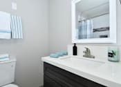 Thumbnail 14 of 21 - A white toilet sits next to a sink in a bathroom.