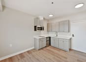 Thumbnail 21 of 25 - a kitchen with white cabinets and a wooden floor at Azure Point at Encinitas, California, 92024