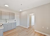 Thumbnail 20 of 25 - a kitchen with gray cabinets and a wooden floor at Azure Point at Encinitas, California