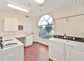 Thumbnail 8 of 25 - a laundry room with white appliances and a large arched window at Azure Point at Encinitas, Encinitas, 92024