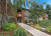 Thumbnail 1 of 21 - a building with a sidewalk and trees in front of it
