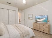 Thumbnail 3 of 29 - A bedroom with a bed, dresser, and a painting of a beach scene on the wall.