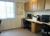 Thumbnail 27 of 27 - A room with a desk, chairs, and a printer.