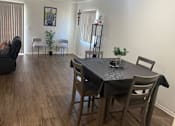 Thumbnail 6 of 25 - A dining room with a table set for two and a couch.