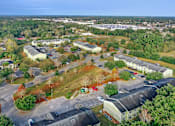 Thumbnail 10 of 14 - A large parking lot is surrounded by buildings and trees.