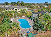 Thumbnail 2 of 14 - A pool surrounded by a fence and trees.