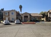 Thumbnail 2 of 7 - A house with a driveway and two parked cars.