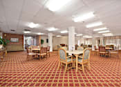 Thumbnail 29 of 31 - A large room with tables and chairs.