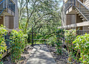 Thumbnail 40 of 43 - A pathway leads through a landscaped courtyard between two apartment buildings.