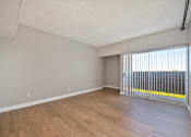 Thumbnail 11 of 31 - Empty room with wooden floor and white walls.