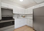 Thumbnail 9 of 31 - A kitchen with white cabinets and a stainless steel refrigerator.