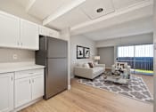 Thumbnail 3 of 31 - A modern kitchen with white cabinets and a black refrigerator.