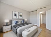 Thumbnail 7 of 31 - A bedroom with a large bed and two nightstands.