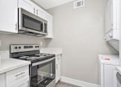 Thumbnail 6 of 43 - A kitchen with white cabinets and appliances.