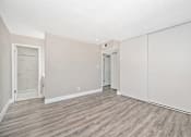 Thumbnail 14 of 43 - A room with a wooden floor and white walls.