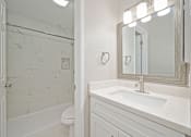Thumbnail 4 of 43 - A white bathroom with a marble tile shower.
