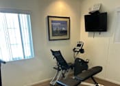 Thumbnail 19 of 27 - A black and white home gym with a treadmill, weights, and a bench.