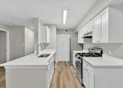 Thumbnail 14 of 27 - A kitchen with white cabinets and appliances.