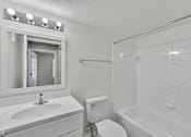 Thumbnail 18 of 27 - A white bathroom with a toilet, sink, and bathtub.