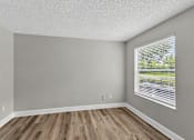 Thumbnail 21 of 27 - A room with wooden floors and a window with blinds.