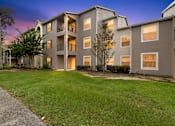 Thumbnail 10 of 27 - A modern apartment building with a well-maintained lawn in front.