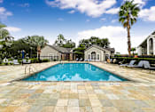 Thumbnail 23 of 27 - A pool surrounded by a tiled patio and lounge chairs.