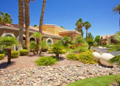 Thumbnail 22 of 31 - a house with palm trees and rocks in front of it