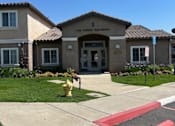 Thumbnail 1 of 27 - The image shows the front of the Los Arboles Apartments with a clear blue sky in the background.
