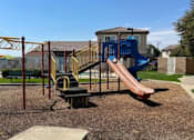 Thumbnail 23 of 27 - A playground with a blue slide and a red slide.