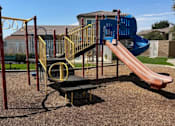 Thumbnail 7 of 27 - A playground with a blue slide and a yellow and black play structure.
