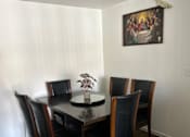 Thumbnail 16 of 27 - A dining table with four chairs and a vase with flowers on it.