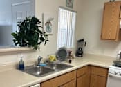 Thumbnail 13 of 27 - A kitchen with wooden cabinets and a white dishwasher.