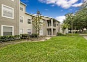 Thumbnail 9 of 27 - A grassy area in front of apartment buildings.