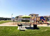 Thumbnail 5 of 27 - A playground with a green umbrella and a slide.