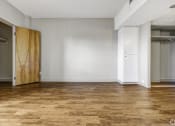 Thumbnail 8 of 27 - an empty room with a wooden floor and a closet