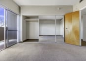 Thumbnail 18 of 27 - a empty room with mirrored doors and a door to a closet