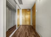 Thumbnail 7 of 27 - a hallway with wood floors and white walls and a door