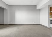 Thumbnail 10 of 27 - the living room of an empty house with a white wall and a stove