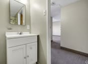 Thumbnail 9 of 27 - a bathroom with a sink and a mirror and a hallway