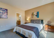 Thumbnail 8 of 25 - a bedroom with a bed and a dresser and a mirror